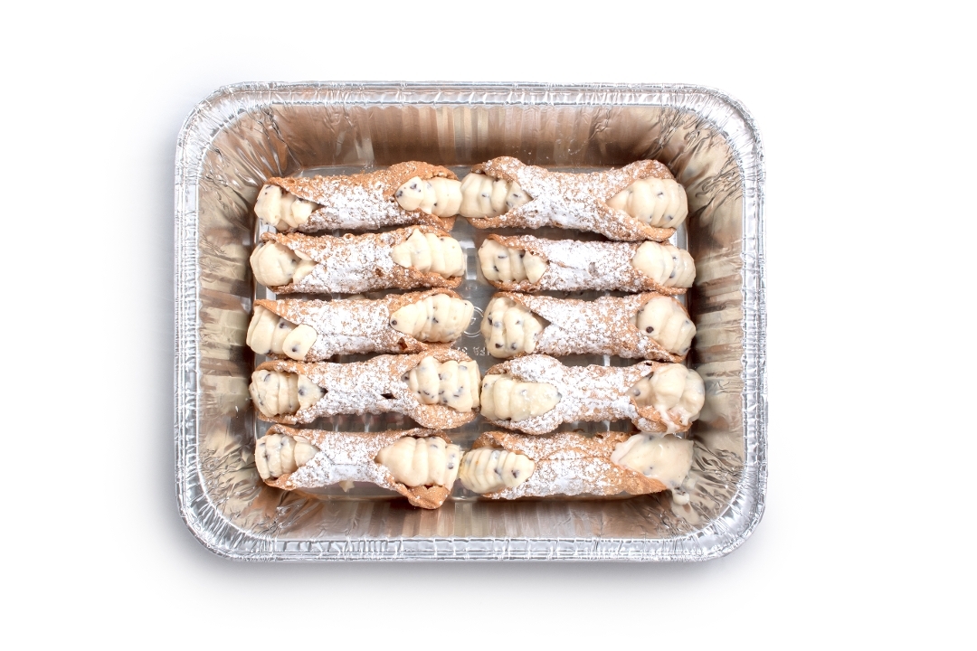 Tray of cannoli dusted with powdered sugar