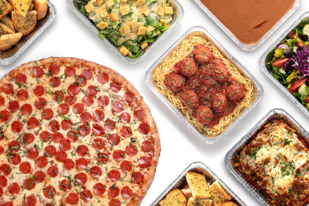 Pizza, pasta, salad, dessert, and garlic bread catering trays
